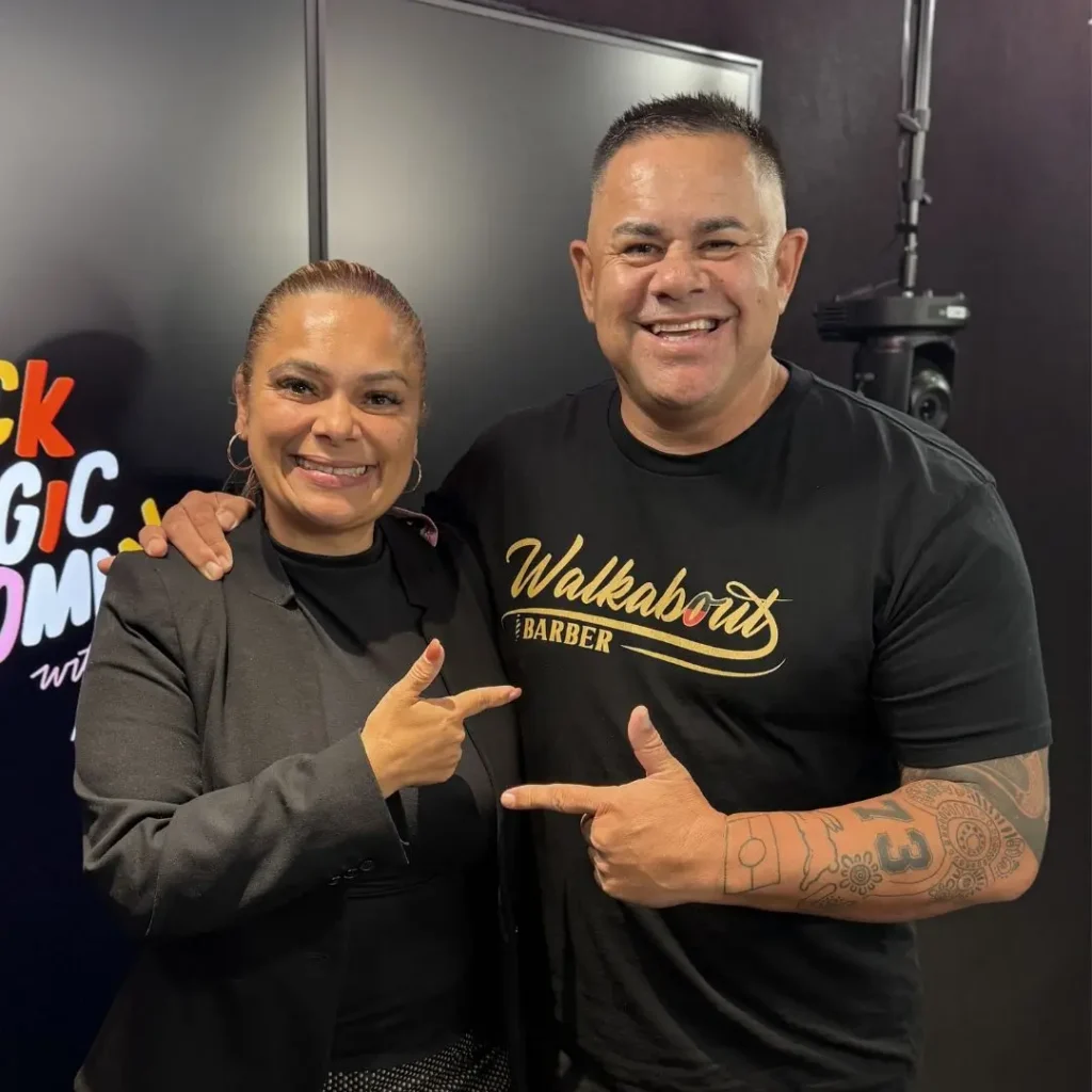 Mundanara Bayles and Brian Dowd in the Black Magic Woman studio, standing next to each other, pointing at each other and smiling to the camera.